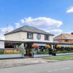 Charming British pub with outdoor seating and flowers.