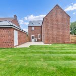 New brick house with large green garden