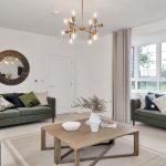 Modern living room with green sofas and large window.