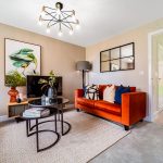 Modern living room with orange sofa and artwork.