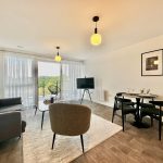 Modern living room with sofa, balcony, dining table.
