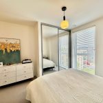 Modern bedroom with large mirror and artwork