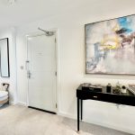 Modern hallway with abstract art and elegant furniture.