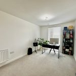 Modern home office with desk and bookcase.