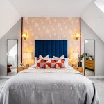 Modern bedroom with colourful bed and skylight.