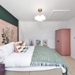 Modern bedroom with pink wardrobe and decorative pillows.