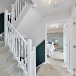 Modern stairway leading to bedroom with patterned wallpaper.
