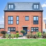 Modern red brick house with garden and flag.