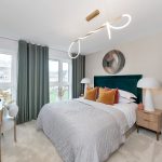 Modern bedroom with pendant light and green curtains.