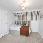 Stylish bedroom with striped accent wall and modern decor.