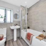 Modern bathroom with bath, toilet, and sink.