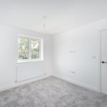 Empty white room with window and radiator.