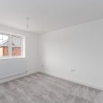 Empty carpeted room with window and radiator