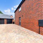 Brick house with driveway and double garage.