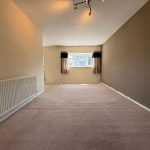 Spacious room with radiator and window curtains