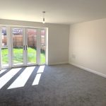 Bright empty room with patio doors to garden.