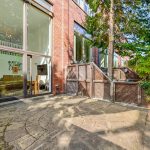 Spacious patio with large windows and trees outside.