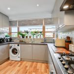 Modern kitchen with appliances and large windows.