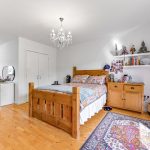 Cosy bedroom with wooden furniture and chandelier.