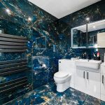 Modern bathroom with marble tiles and white fixtures.