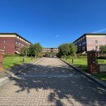 Brick office buildings with a path and greenery.