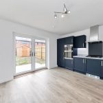 Modern kitchen with dark cabinets and patio doors.