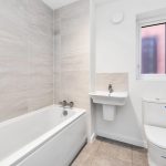 Modern bathroom with bathtub, sink, and toilet.