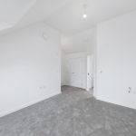 Empty room with carpet and white walls.