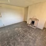 Empty room with fireplace and window view.