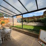 Patio with table, grass, and garden view