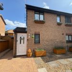 Brick house with garden planters and white door.