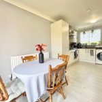 Kitchen with dining table and modern appliances.