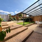 Outdoor patio with covered seating area and steps.