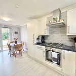 Modern kitchen with dining table and garden view.