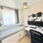 Compact bedroom office with dual monitors.