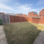 Small fenced garden with grass and a shed.