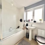 Modern bathroom with bathtub, sink, and toilet.