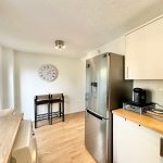 Modern kitchen with appliances and seating area view.
