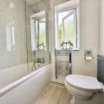 Modern bathroom with shower and window.