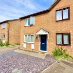 Brick townhouse with blue door, front garden