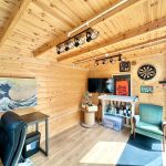 Wooden home office with bar and dartboard.