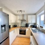 Modern kitchen with appliances and wooden countertops.
