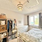 Cosy bedroom with storage and window view.