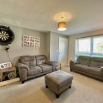 Modern living room with sofas and dartboard.