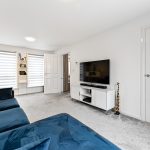 Modern living room with TV and blue sofa.