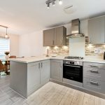 Modern kitchen with grey cabinets and dining area.