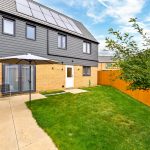Modern semi-detached house with garden and solar panels.