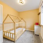 Child's bedroom with wooden house-shaped bed.