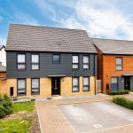 Modern detached house with driveway and garden.