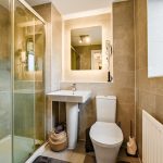 Modern bathroom with shower, sink, and toilet.